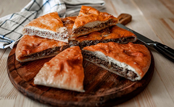 Скидка на Осетинские пироги с мясом, сыром, грибами и не только, а также ароматная пицца от пекарни «Пироги Табу». Скидка до 68%